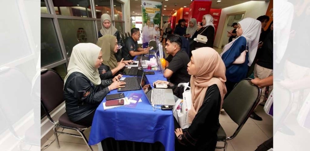 PESERTA tidak melepaskan peluang mendengar taklimat di reruai PTPTN.