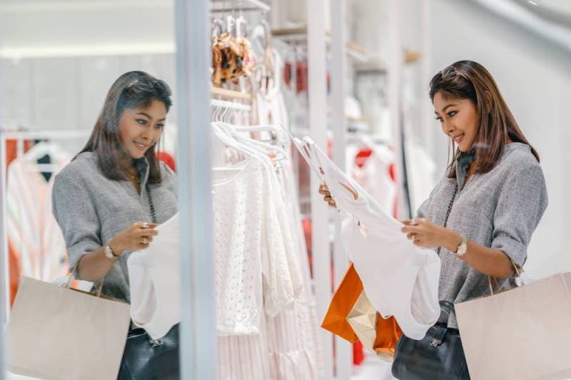 Asian woman looking and choosing the underwear in store shop with happy action at department center