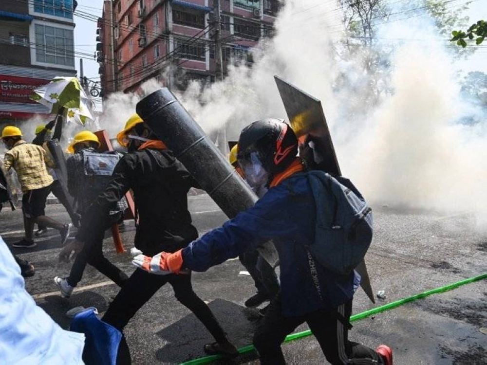 Gambar fail menunjukkan para penentang rampasan kuasa tentera cuba melindungi diri daripada terkena gas pemedih mata pihak berkuasa di Yangon, Myanmar. - Foto AFP