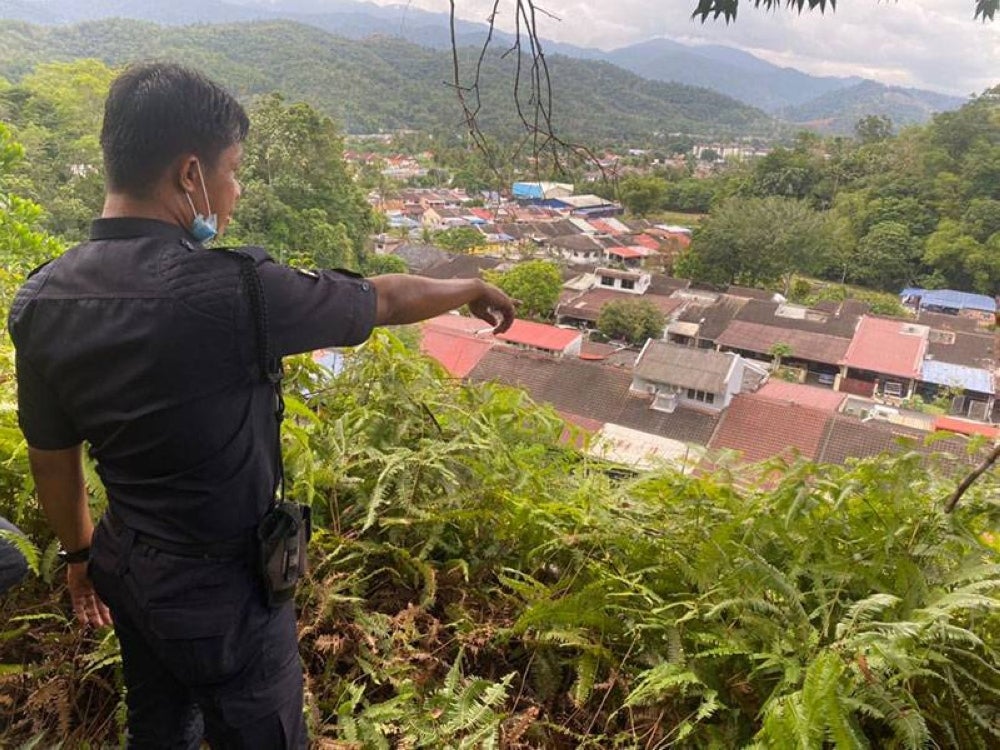 Mohd Suhaimi menunjukkan lokasi Rambo Bentong di atas bukit.