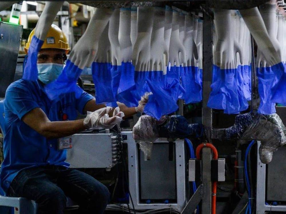 Sepatutnya sejak awal lagi kerajaan bekerjasama dengan pemilik kilang, pemaju hartanah, kontraktor dan pembekal perkhidmatan untuk berkongsi kos vaksinasi bagi setiap pekerja. - Foto AFP
