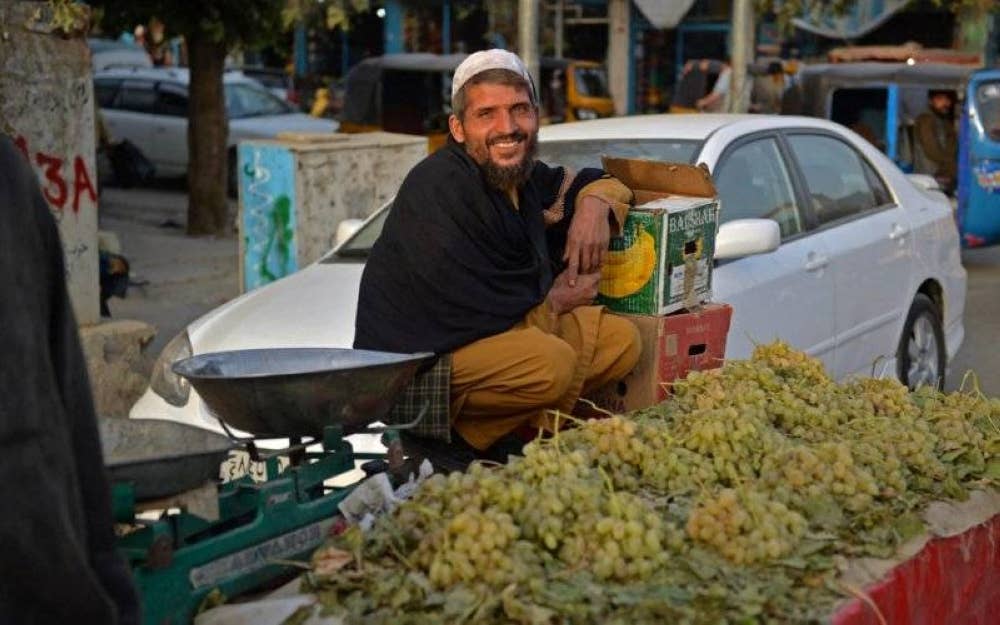 Seorang peniaga menjual buah anggur menunggu pelanggannya di tepi jalan di daerah Kunduz. - AFP