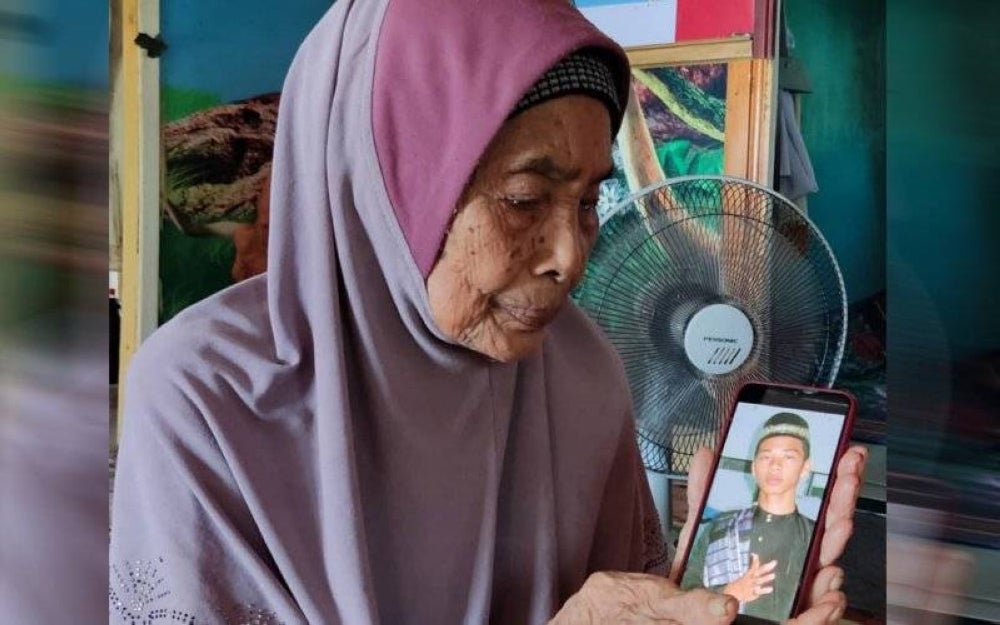 Jamnah menunjukkan gambar cucunya, Mohd Azrul yang hilang di laut pada 7 Mac 2018 dan gagal ditemui hingga hari ini.