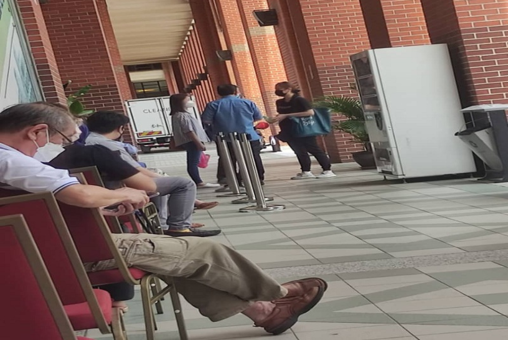 Mohd Shafiq (tengah) sedang berbual dengan dua wanita dipercayai majikan yang berurusan di bangunan KSM, Putrajaya pada Isnin.