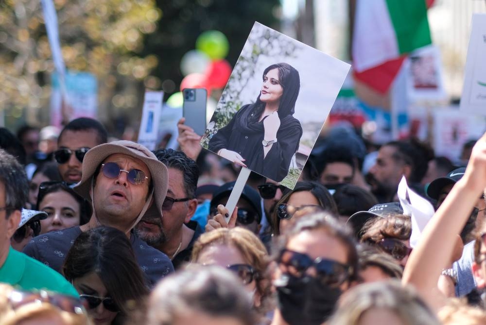 Penunjuk perasaan memegang gambar Mahsa Amini ketika demonstrasi di pusat bandar Los Angeles, California, Amerika Syarikat pada Sabtu. - Foto EPA
