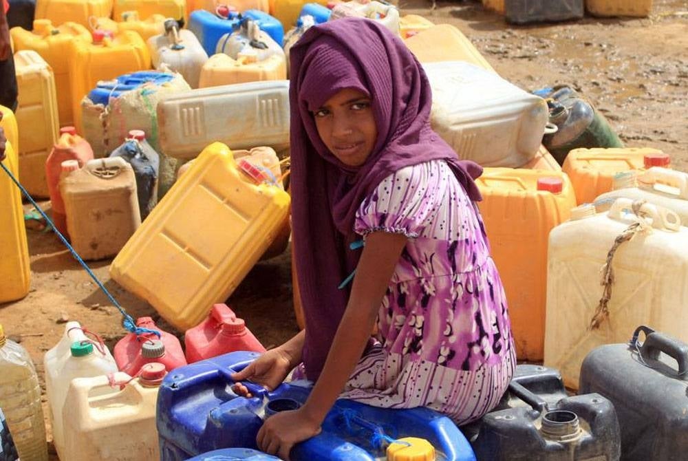 Sorang kanak-kanak Yemen sedang menunggu bekalan air bersih di kem pelarian di Hajjah. - Foto Agensi