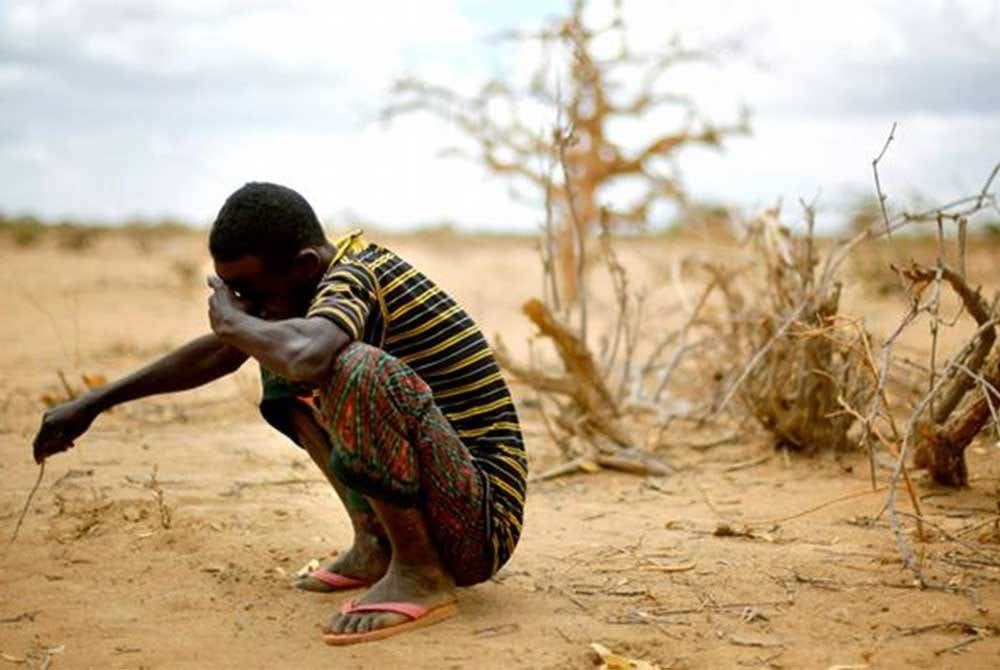 Seorang lelaki kelihatan sedih apabila melihat kawasan tanaman yang kering akibat kemarau di Afrika. - Agensi