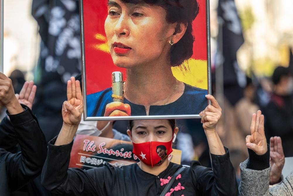 Aktivis pro demokrasi memegang gambar Suu Kyi semasa tunjuk perasaan di Tokyo. - AFP