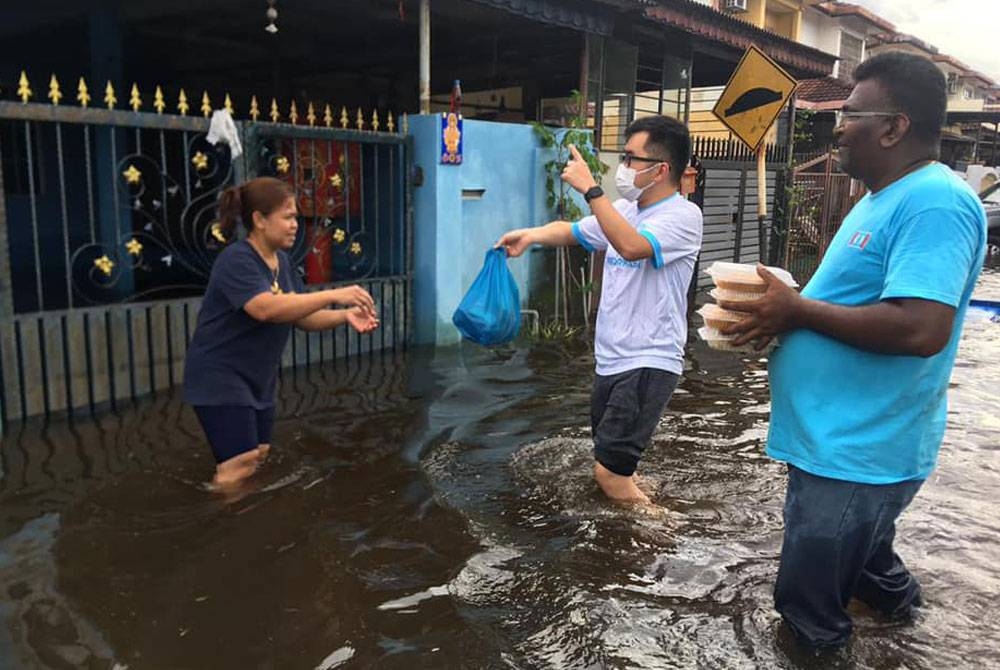 Wee Kiat menyerahkan bantuan kepada penduduk di kawasan terjejas ketika berlaku
banjir kilat di Rawang baru-baru ini.