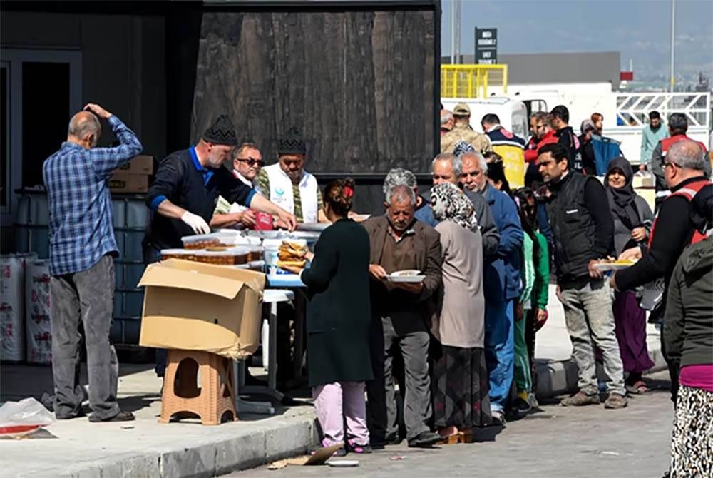 Penduduk terjejas gempa menunggu giliran untuk mendapatkan makanan yang disediakan sukarelawan di Hatay.