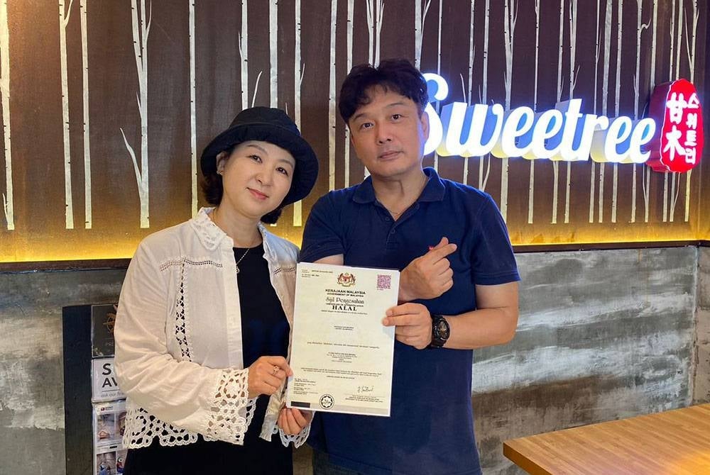 Hey Jin (kiri) bersama suaminya, Park Kyung Kyoo (kanan) menunjukkan sijil halal yang diperoleh mereka.