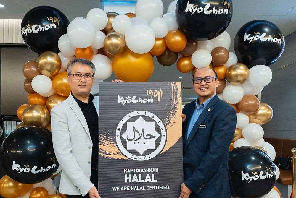 Terry (kiri) dan Ketua Penolong Pengarah Kanan, Bahagian Pengurusan Halal Jakim, Mohd Fakarudin Mas'od sewaktu Majlis Penyampaian Sijil Halal Jakim kepada KyoChon 1991 Malaysia pada12 Mei lalu.