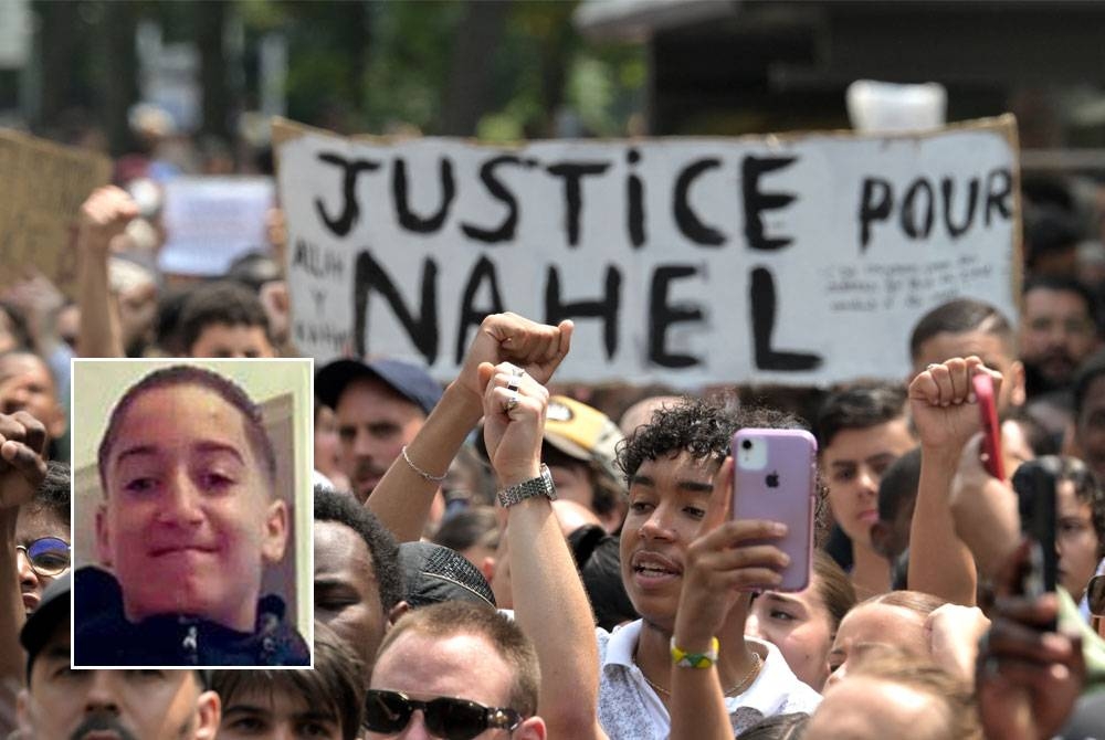 Penunjuk perasaan membawa kain rentang bertulis 'Keadilan untuk Nahel' semasa melakukan perarakan di Nanterre. Gambar kecil: Nahel Merzouk.