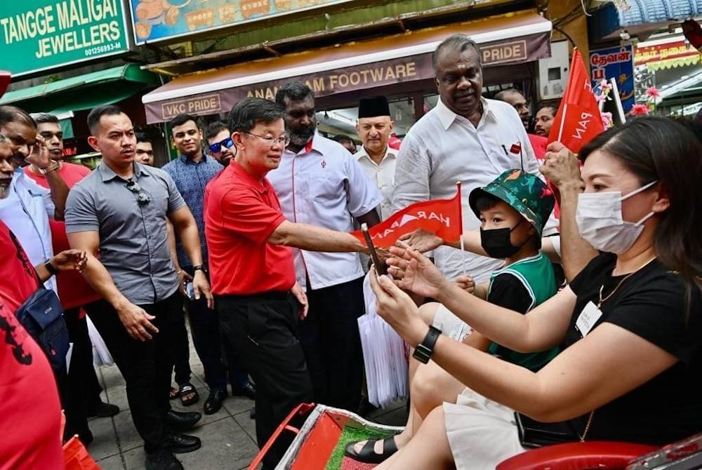 Kon Yeow (kiri) ketika menyantuni para pengundi ketika berkempen untuk PRN di Pulau Pinang.