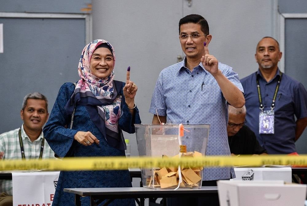 Mohamed Azmin (tiga, kiri) dan isteri, Datin Seri Shamshida Taharin (dua, kiri) mengundi di Sekolah Kebangsaan Klang Gate pada Sabtu.