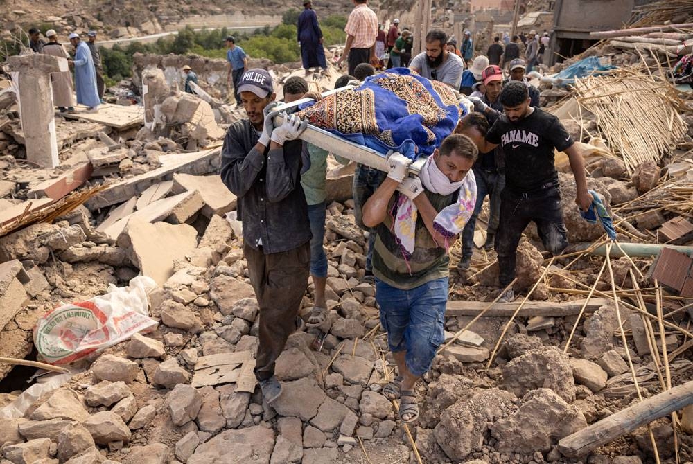 Beberapa sukarelawan mengusung mayat mangsa yang dibawa keluar dari bawah runtuhan di perkampungan Imi N'Tala berhampiran Amizmiz.