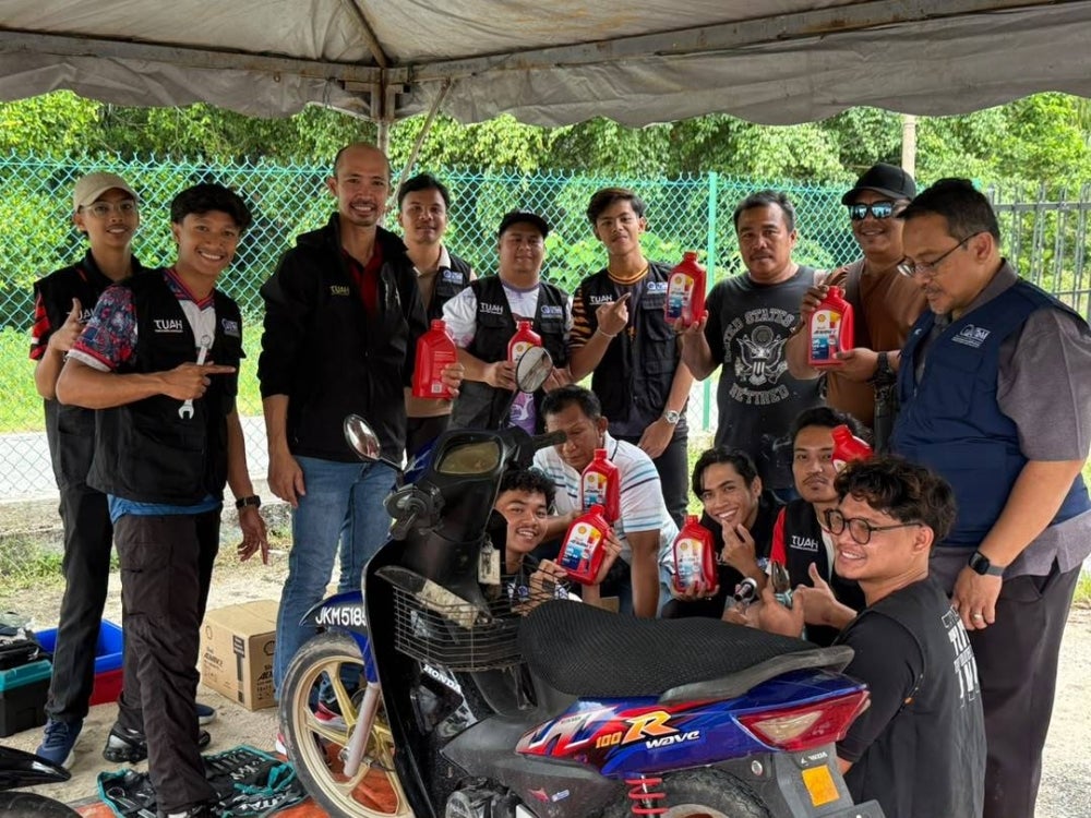 Mahasiswa UTeM bergambar ketika membuat persediaan pelaksanaan aktiviti penukaran minyak hitam motosikal yang memberi manfaat kepada penduduk Kampung Nelayan, Parit Jawa, Johor sempena Program UTeM@KPT Prihatin.
