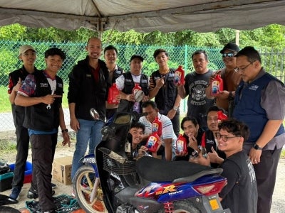  Mahasiswa UTeM bergambar ketika membuat persediaan pelaksanaan aktiviti penukaran minyak hitam motosikal yang memberi manfaat kepada penduduk Kampung Nelayan, Parit Jawa, Johor sempena Program UTeM@KPT Prihatin.