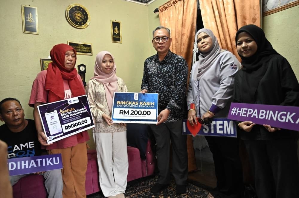 Nurul Amira menerima kunjungan Mohd Zamri (tiga dari kanan) yang hadir menyerahkan bantuan termasuk kewangan bagi meringankan beban yuran pengajiannya ke UMT.