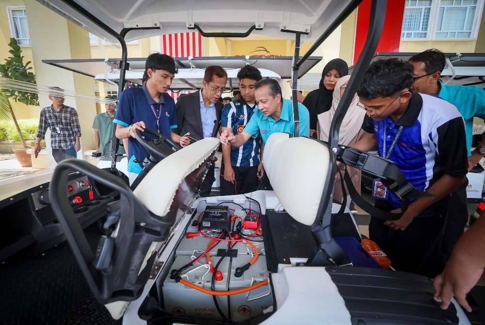 Mohd Zamre (dua dari kiri) melihat pelajar semester tiga Diploma Kejuruteraan Elektrik (tenaga hijau) mengemaskini projek panel solar yang dipasang pada kereta buggy pada sesi demonstrasi dan promosi Projek Inovasi Teknologi Solar Buggy Car di Politeknik Jeli hari ini.