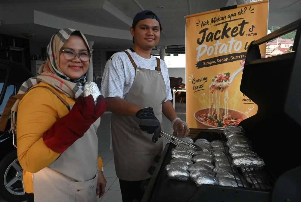 Pengusaha D’s Kentang, Danish Ekmal Edham, 23, (kanan) bersama ibunya, Norazah Zainal, 50, menunjukkan kentang jenis Russet, yang perlu dibakar sehingga rangup sebelum diletakkan ‘topping’ untuk dijual kepada pelanggan.
Sehingga kini, Danish menyediakan empat jenis ‘topping’ iaitu original classic (kacang panggang), creamy chicken, black paper beef dan juga big mac beef.