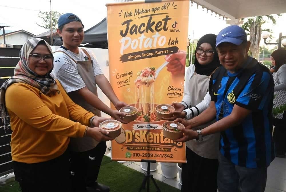 Pengusaha D’s Kentang, Danish Ekmal Edham, 23, (dua, kiri) bersama ibu dan bapanya, Norazah Zainal, 50, (kiri) dan Edham Wahab, 50, (kanan) serta adiknya, Dya Edlyn Edham, 22, menunjukkan Jacket Potato yang juga dikenali Spud Potato yang dijualnya sejak Januari lalu.
Bermula dengan hanya enam biji kentang bakar sehari dijual di hadapan rumah, Danish Ekmal kini mampu menjual lebih 250 hidangan Jacket Potato atau Spud Potato setiap hari selepas menu berkenaan mendapat sambutan luar biasa daripada pelanggan.