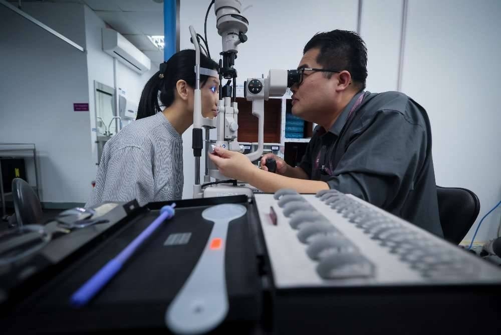 Pakar Oftalmologi Hospital Pakar Universiti Sains Malaysia (HPUSM) Dr Ng Kwang Sheng memeriksa tahap kesihatan mata pesakitnya menggunakan alat ujian mata bagi mengenal pasti masalah juling atau strabismus di HPUSM.
