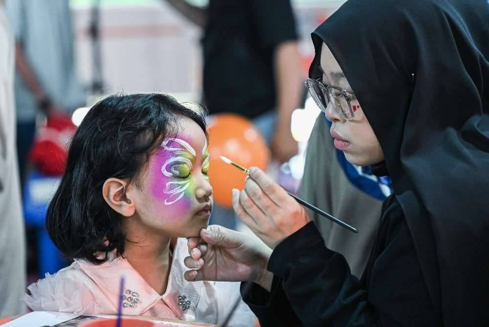 Penuntut Ijazah Sarjana Muda Produksi Animasi 2D Universiti Teknologi MARA Nur Farina Izzatul Daur, 23, melukis wajah pelanggan ciliknya selepas tayangan eksklusif siri animasi terbaharu Build-It Blocks.