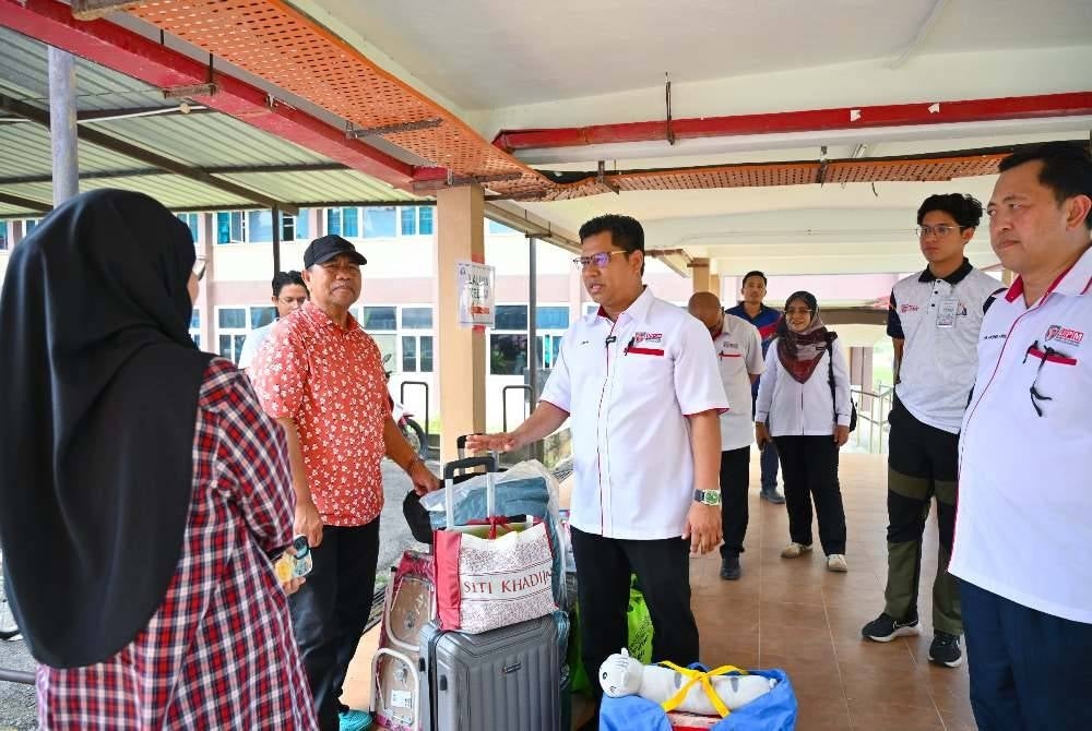 Dr. Arifin (tengah) beramah mesra dengan ibu bapa yang menghantar anak-anak mendaftar di Kolej Zaaba.
