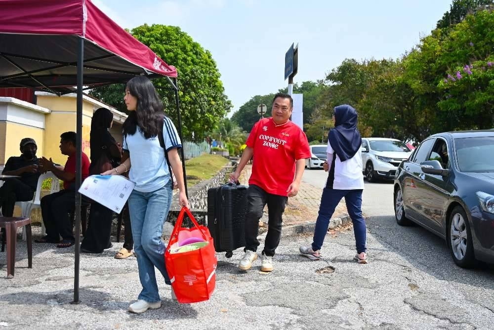 Ibu bapa yang bersama anak-anak membawa barangan keperluan semasa hari pendaftaran.
