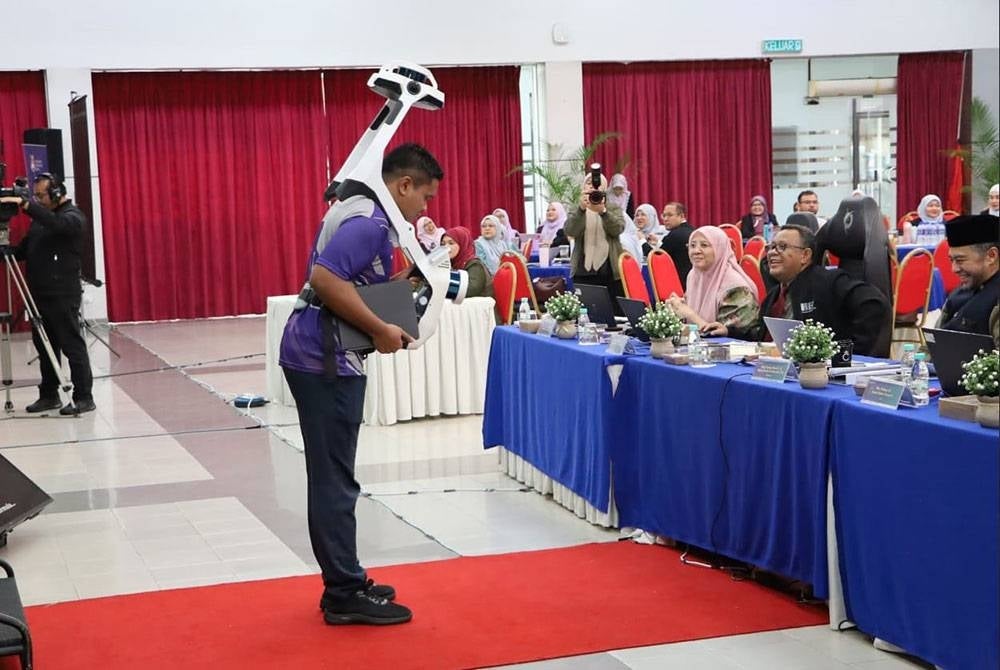 Warga Jabatan Pembangunan (JP UiTM) memdemonstrasikan pengisian alat pengimbas canggih NavVis VLX-3 Wearable Laser Scanner di hadapan barisan panel juri sempena Pembentangan Akhir Anugerah Kualiti Naib Canselor (AKNC) 2026 di Anjung Seri Budiman, UiTM Shah Alam.
