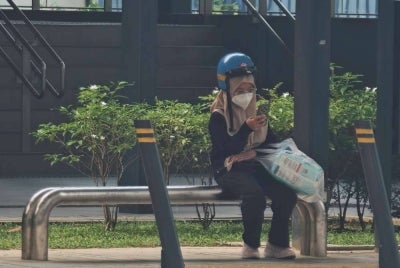 Seorang wanita memakai pelitup muka bagi mengurangkan pendedahan kepada jerebu ketika berada di kawasan terbuka di Kuala Lumpur. - Foto Bernama
