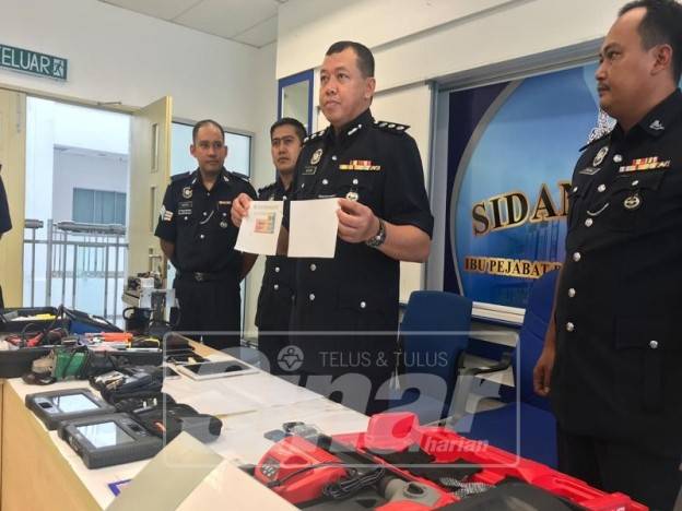 Azhan menunjukkan cukai jalan palsu yang dihasilkan suspek bagi menjual kenderaan mewah dicuri.