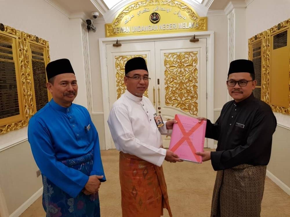 Adly Zahari menerima fail Bajet 2019 Melaka daripada Pegawai Kewangan negeri, Datuk Hanafi Sakri sebelum membentangkannya, semalam. Turut kelihatan, Setiausaha Kerajaan Negeri, Datuk Seri Roslan Ibrahim (kiri).