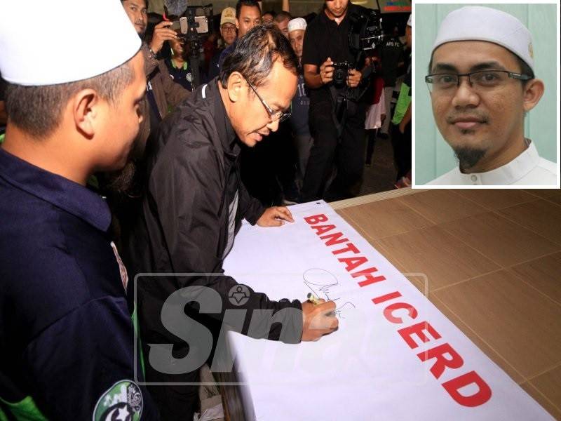 Dr Samsuri menurunkan tandatangan pada kain rentang disediakan sempena majlis penyamoaian hadiah, malam tadi. (Gambar kecil: Mohd Aswadi Mohamad.)