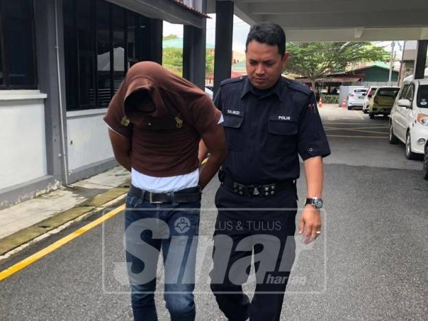 Tertuduh (kiri) dikawal polis keluar dari mahkamah dan dihantar ke penjara untuk menjalani hukuman akibat kesalahan cabul