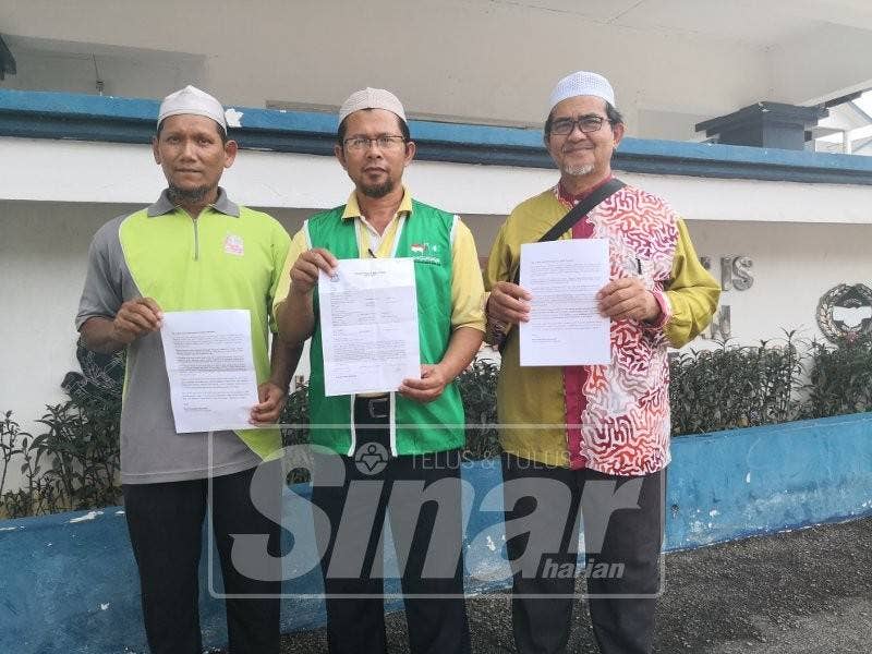 Mohd Nasaruddin (tengah) dan wakil Pas Negeri Sembilan lain menunjukkan laporan polis dibuat di IPD Seremban.