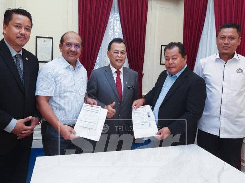 Rasman (dua, kiri) dan Rosleli (dua, kanan) menyerahkan borang keahlian Bersatu kepada Osman.
