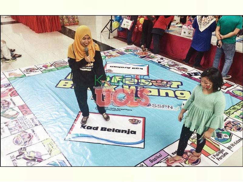 Petugas PTPTN ketika membantu para peserta yang bermain dalam permainan Profesor Bijak Wang.