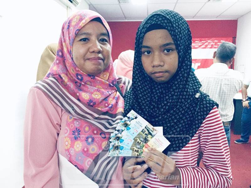 Alia Syazwani bersama ibunya, Dahniar gembira berjaya menebus tiket percuma ke taman tema di Bukit Gambang Resort City.