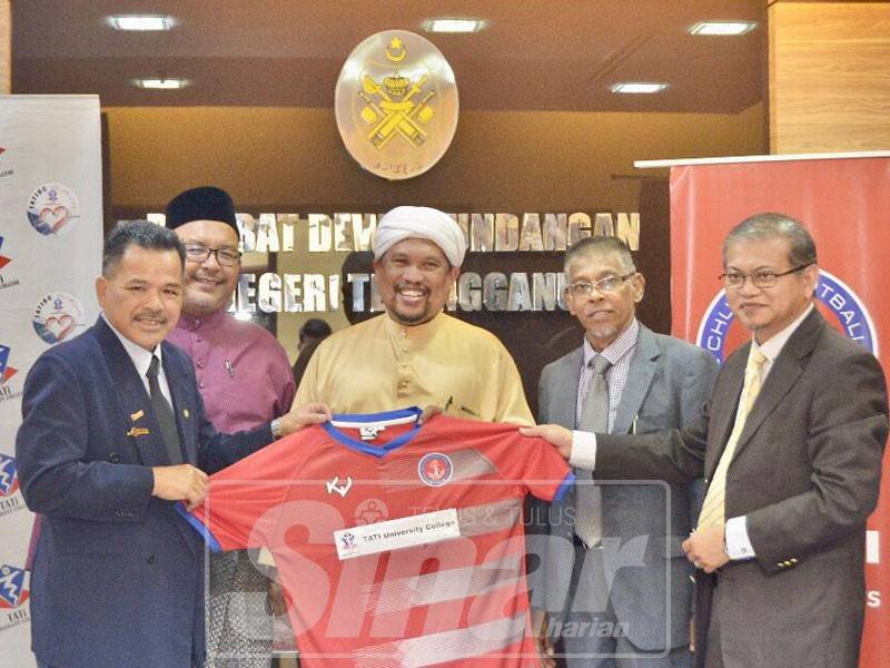 Ahmad (kiri) menyerahkan jersi kelabnya yang tertera logo Tatiuc kepada Anuar (kanan) sambil disaksikan Pengerusi Lembaga Pengarah Tatiuc, Satiful Bahri Mamat (tengah), Exco Pembangunan Belia, Sukan dan Badan Bukan Kerajaan (NGO), Wan Sukairi Wan Abdullah (dua, kiri) dan Adun Chukai, Hanafiah Mat.