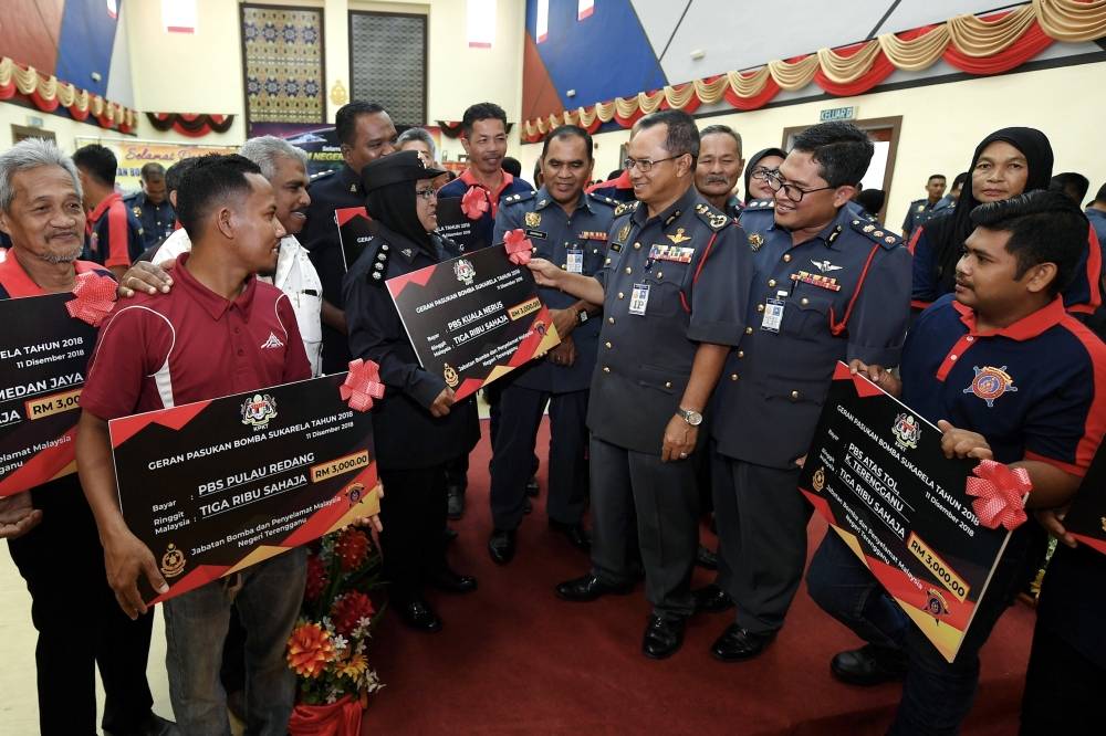 KUALA TERENGGANU, 11 Dis -- Timbalan Ketua Pengarah Bahagian Operasi Jabatan Bomba dan Penyelamat Malaysia (JBPM) Datuk Amer Yusof (tiga, kanan) beramah mesra dengan Pengerusi Pasukan Bomba Sukarela (PBS) yang menerima geran bantuan kewangan pada Majlis Penyampaian Geran Bantuan Kewangan Kepada Pasukan Bomba Sukarela (PBS) di Ibu Pejabat Bomba Negeri Terengganu hari ini. -Foto Bernama