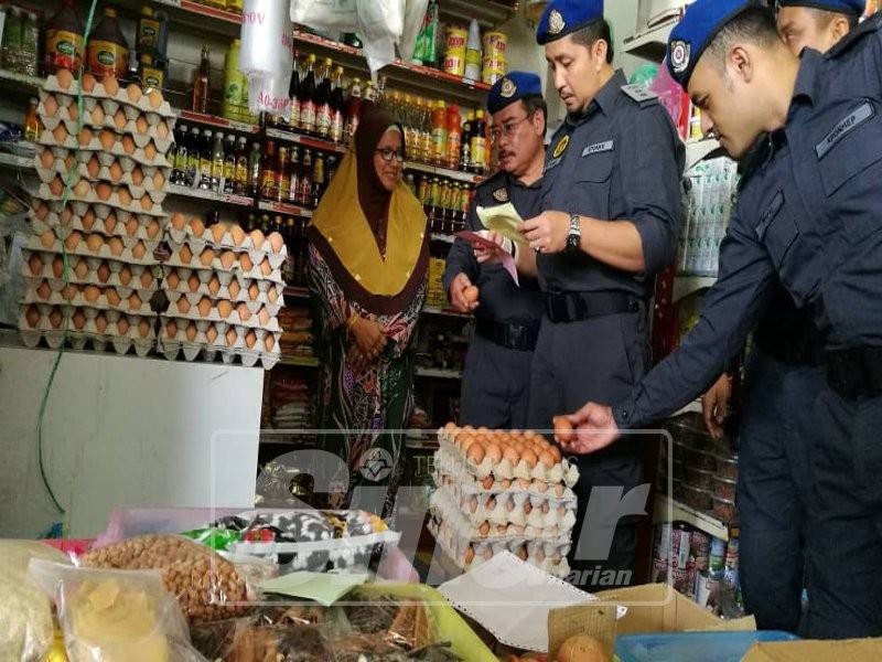 Zulfamy (tiga dari kiri) memeriksa senarai harga telur daripada seorang peruncit di Pasar Besar Kuala Berang, Hulu Terengganu, hari ini sewaktu Operasi Bersepadu Bersama Agensi Penguatkuasa Negeri Terengganu.
