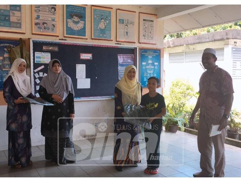 Rohana turut menyampaikan beg sekolah kepada kanak-kanak.