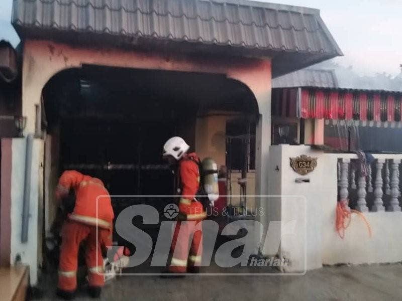 Anggota bomba ketika melakukan kerja pemadaman api di rumah teres yang terbakar di sini pagi tadi.