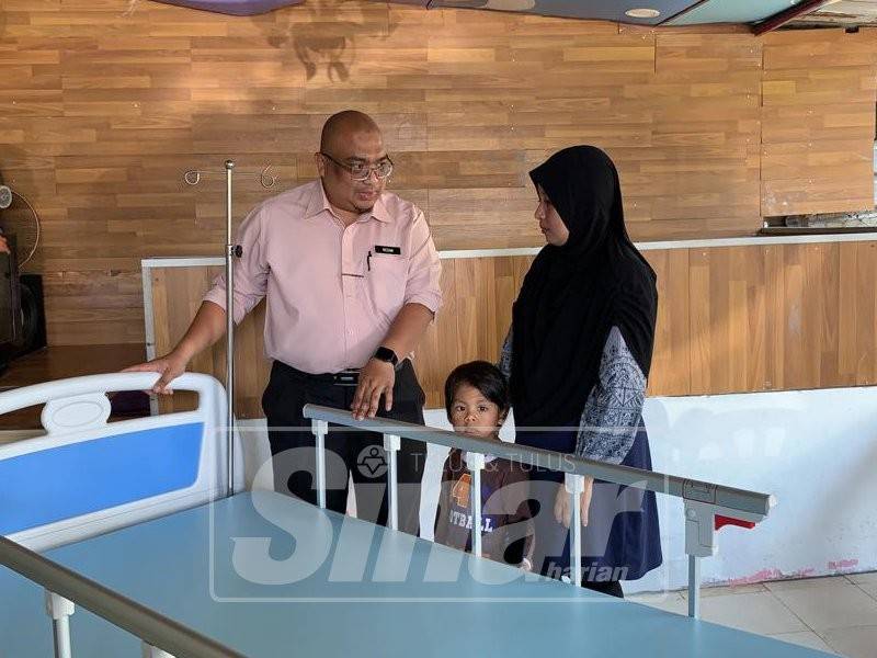 Zaizalnizam mewakili Khalid menyerahkan sumbangan katil khas kepada Roshidah untuk kegunaan suami yang lumpuh.