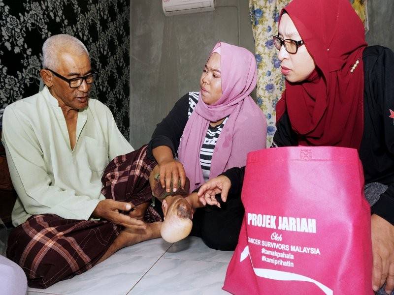 Pengasas Cancers Survivors Malaysia (CSM), Zuraini Kamal (kanan) melihat kaki kiri pesakit kanser darah, Jasni Othman, 60, yang kudung terkena jerangkap samar ketika operasi tentera di Gubir pada 1986 ketika ditemui di rumahnya di Taman Kita, ALor Setar hari ini. - Foto Bernama 