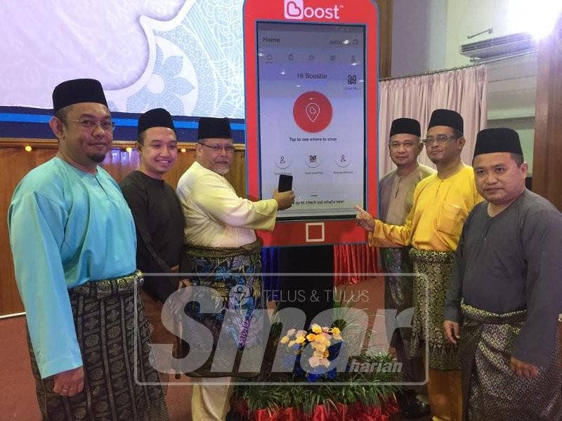 Aminolhuda (tiga, kiri) melakukan gimik perasmian mencuba sistem Boost untuk Tabung Pembangunan Masjid dan Amal Jariah Johor yang kini boleh digunakan atas talian.