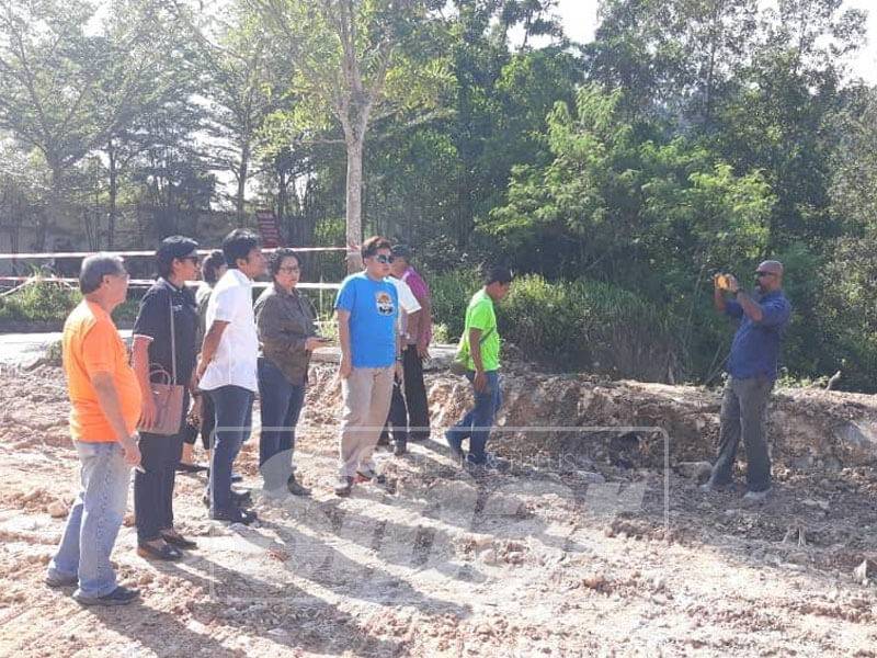 Beberapa penduduk bersama Najwan dan Gandhimathi meninjau aktiviti pembangunan di hutan berhampiran Taman Bukit Bayu.