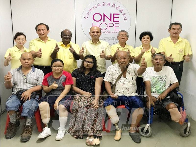 Penerima bantuan kaki palsu bergambar bersama jawatankuasa badan kebajikan One Hope selepas majlis penyerahan yang diadakan awal tahun ini.